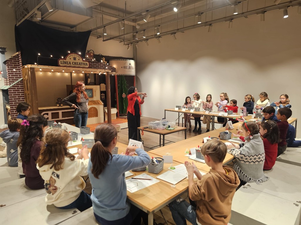 Grupo de niños en taller creativo con dos monitoras en Salamanca