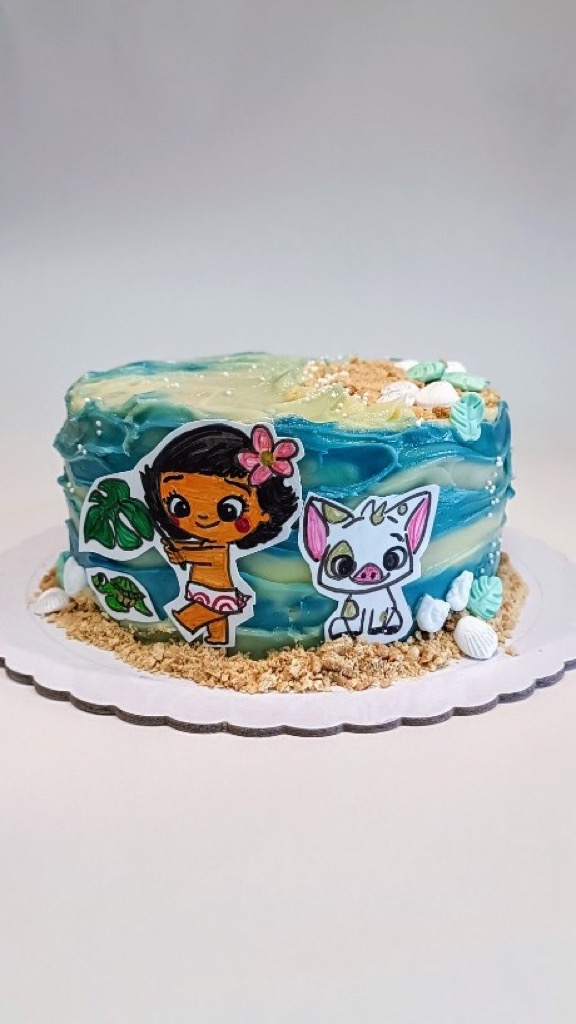 Tarta temática Vaiana con olas en buttercream y personajes recortados en la base