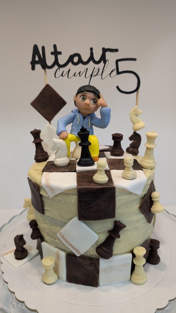 Tarta temática ajedrez con tablero, piezas y figura de niño pensando en porcelana fría