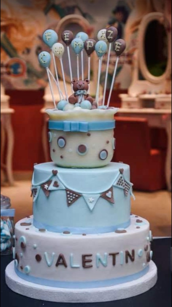 Tarta de tres pisos azul y beige con osito, guirnalda y globos FELIZ CUMPLE
