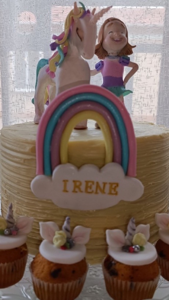 Tarta con unicornio arcoíris, figura de niña y cupcakes a juego en porcelana fría